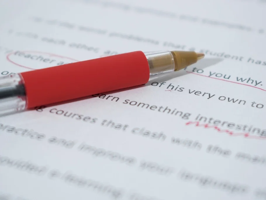 Red pen on a printed page being proofread
