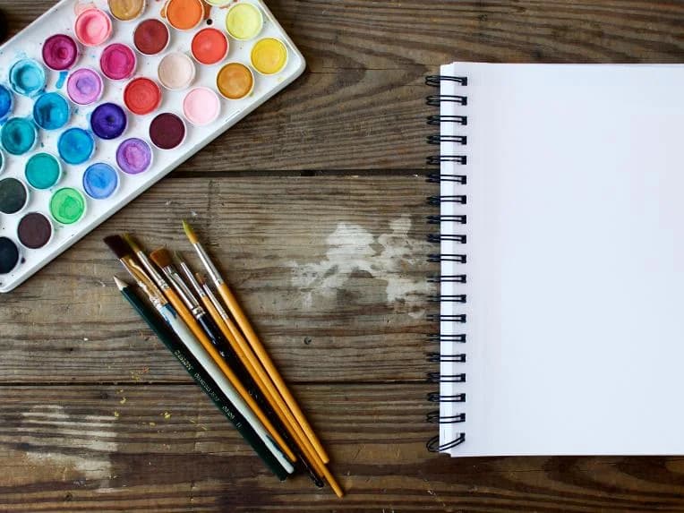 Watercolour palette, brushes and a blank sketchbook
