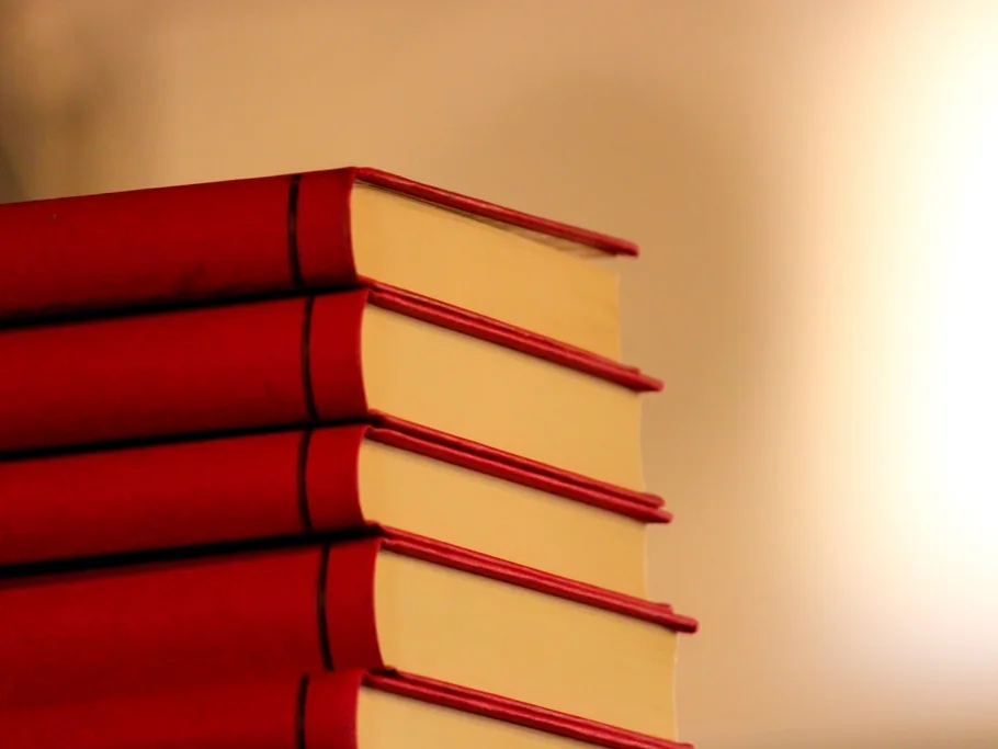 A stack of red hardcover books